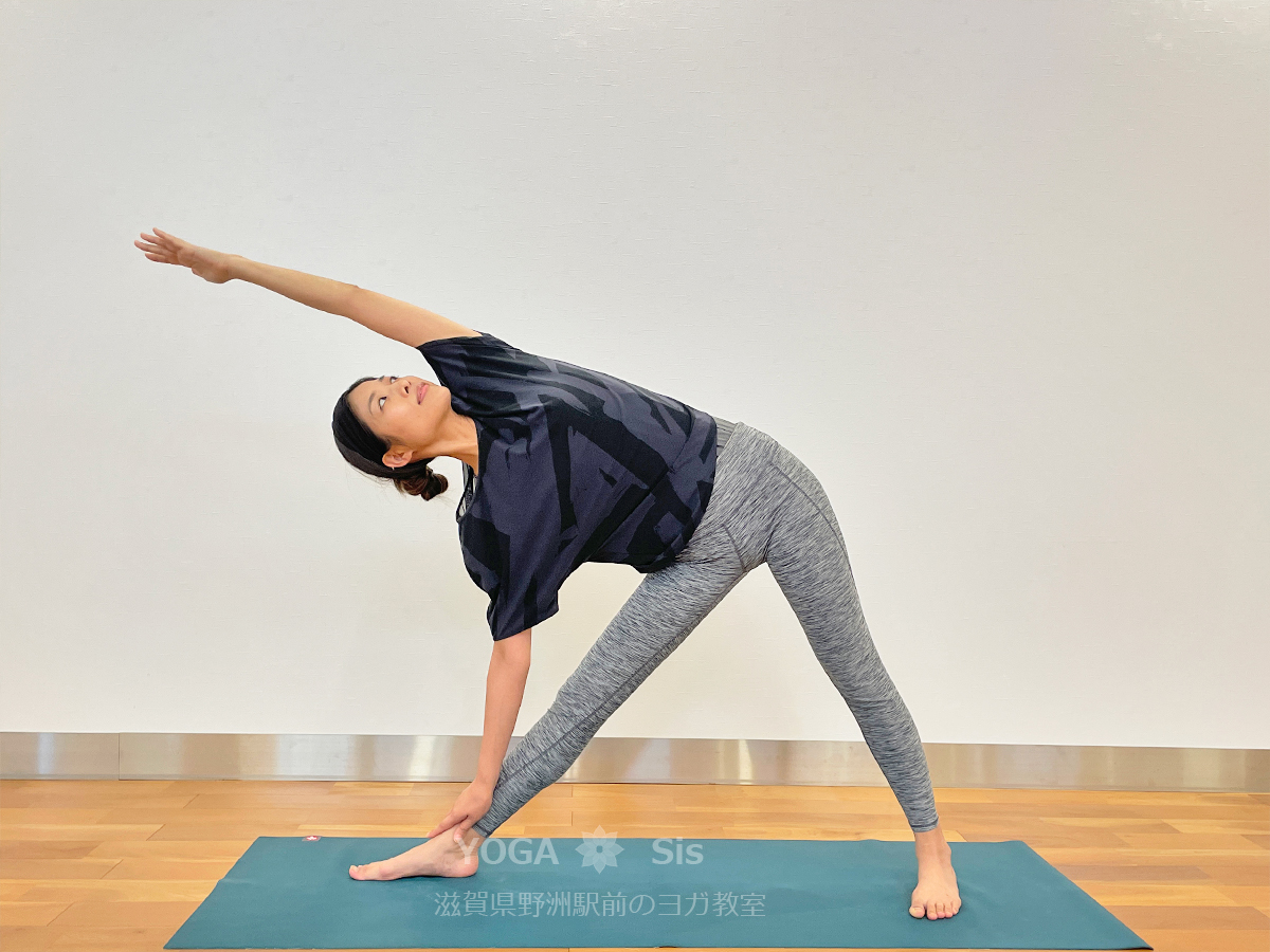 三角のポーズ上の手を耳の横まで倒す